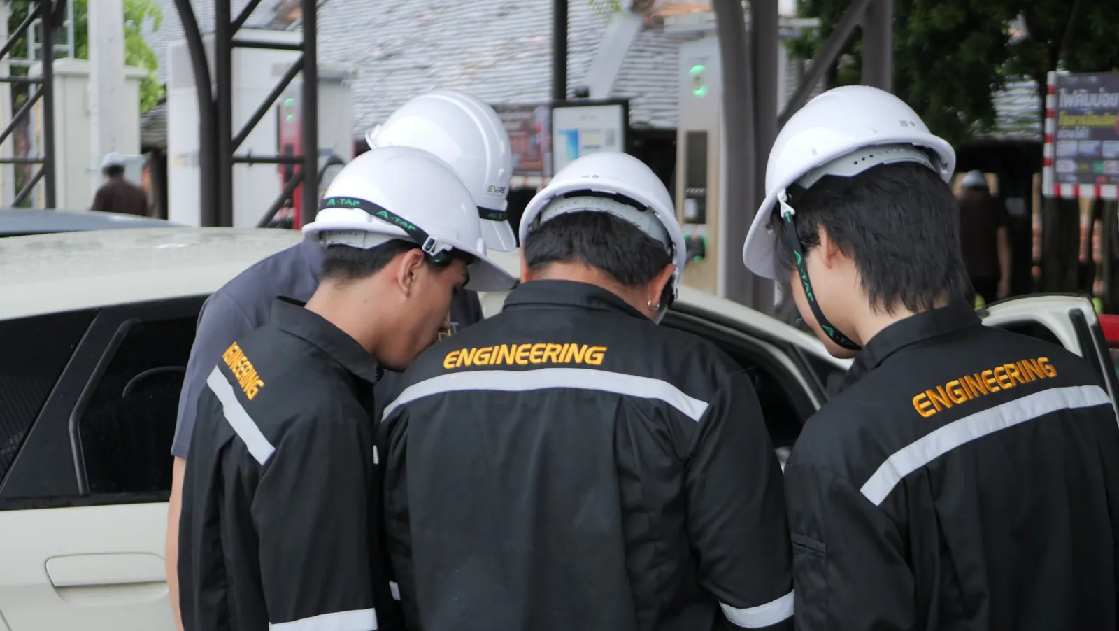 นักศึกษาสวมหมวกนิรภัยตรวจเช็ครถยนต์ไฟฟ้าร่วมกัน